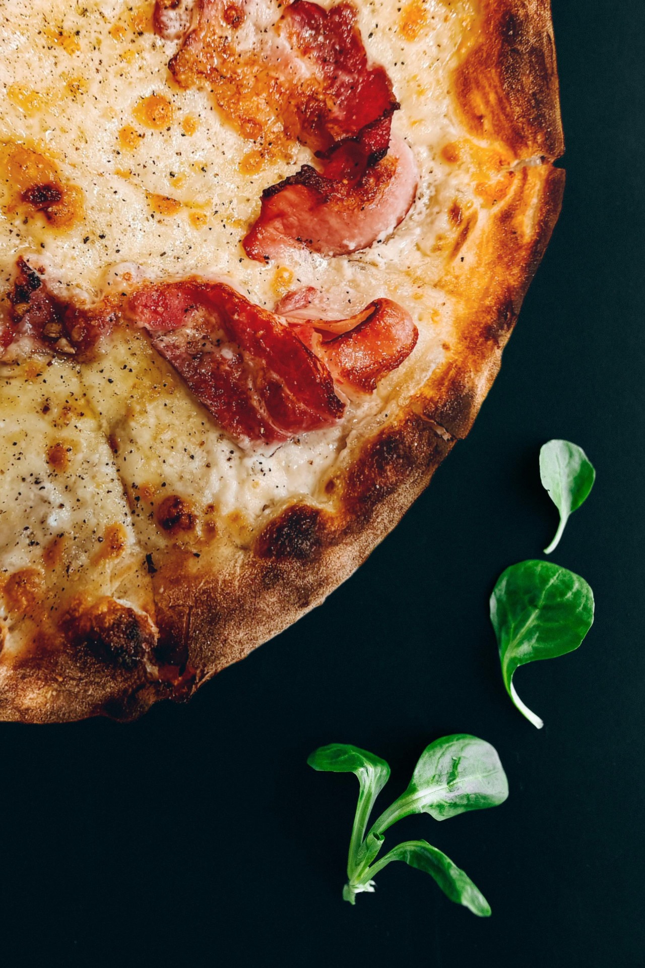 Cheese pizza with bacon and herbs from above