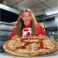 Customer holding a large Villa Pizza pie in a Rutgers shirt